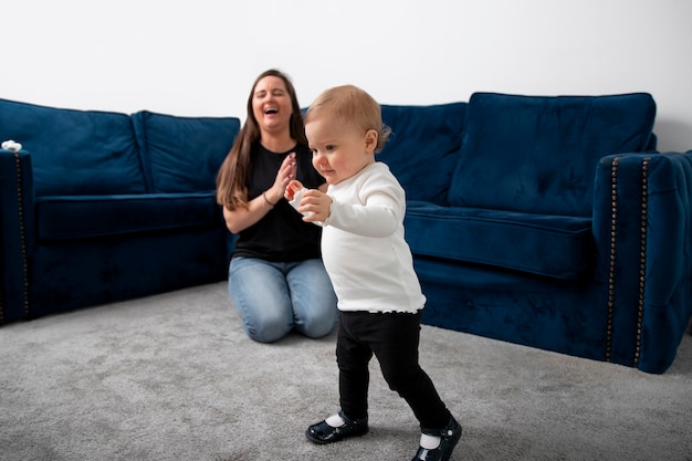 Mujer y niño sonrientes de tiro completo en casa