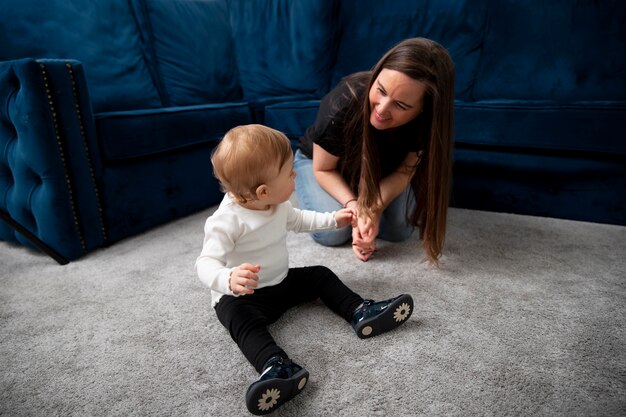 Mujer y niño sonrientes de tiro completo en el interior