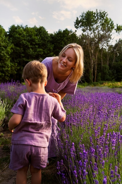 Mujer y niño sonrientes de tiro completo en la naturaleza