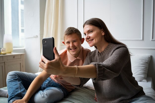 Mujer y niño sonrientes de tiro medio tomando selfie