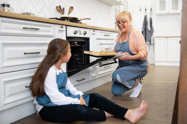 Mujer y niño de tiro completo en la cocina