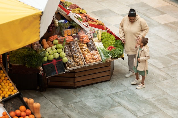 Mujer y niño de tiro completo en el mercado