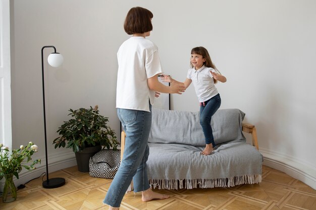 Mujer y niño de tiro completo en la sala de estar