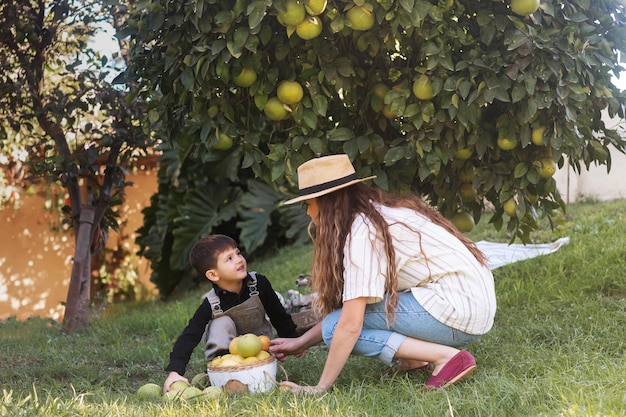 Foto gratuita mujer y niño de tiro completo sobre el césped