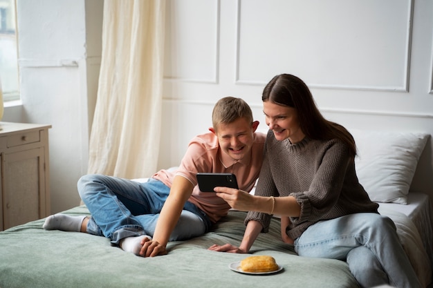 Mujer y niño de tiro completo con teléfono inteligente