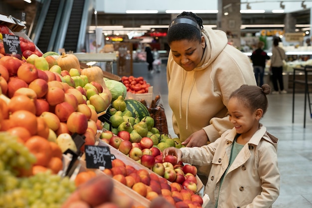 Foto gratuita mujer y niño de tiro medio en el mercado