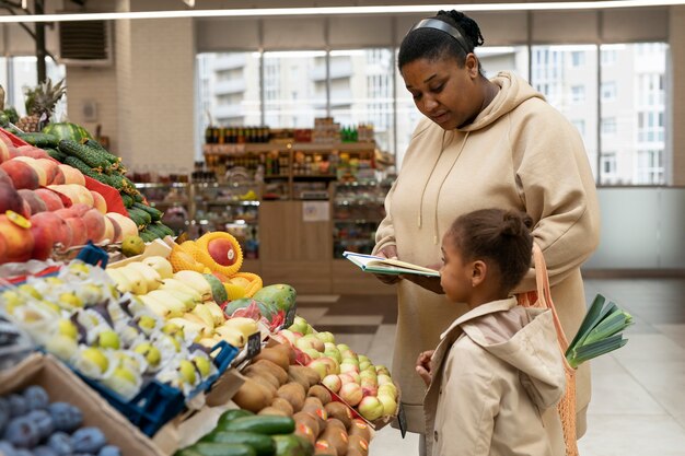 Mujer y niño de tiro medio en el mercado