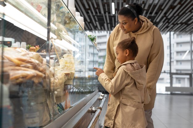 Mujer y niño de tiro medio en el mercado