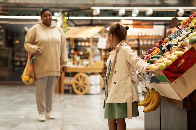 Mujer y niño de tiro medio en el mercado