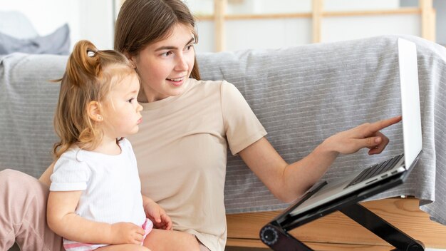 Mujer con niño trabajando en la computadora portátil