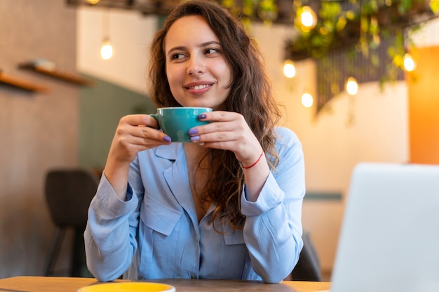 Mujer nómada sonriente con café