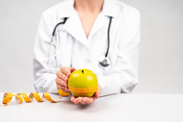 Mujer nutricionista sosteniendo una manzana