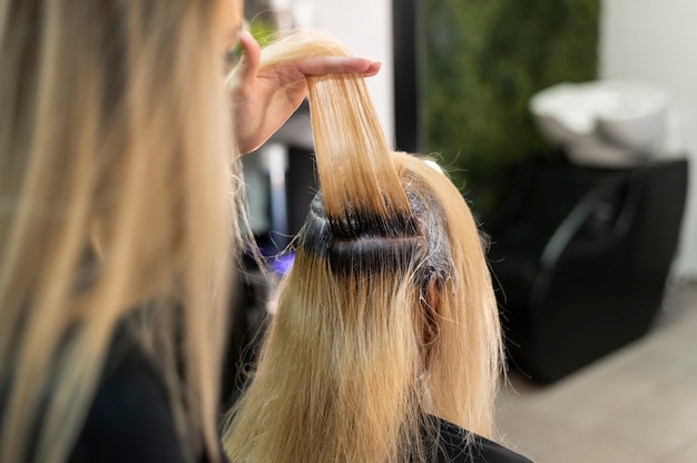 Mujer obteniendo su cabello teñido en el salón de belleza