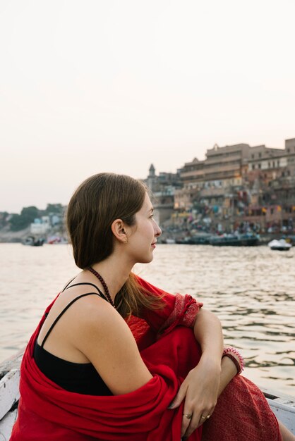 Mujer occidental en un barco explorando el río Ganges