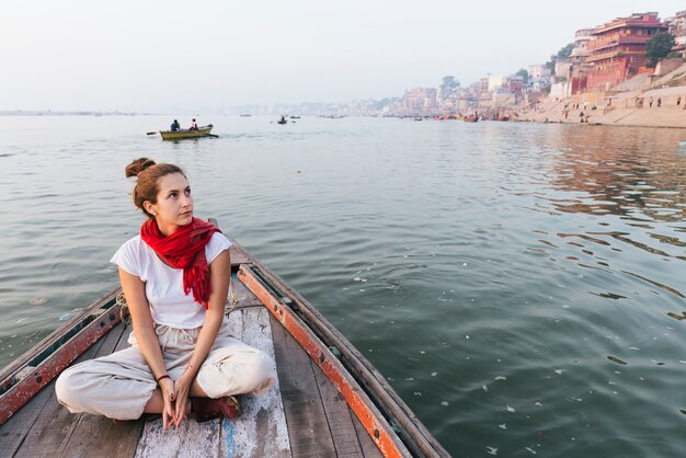 Mujer occidental en un barco explorando el río Ganges