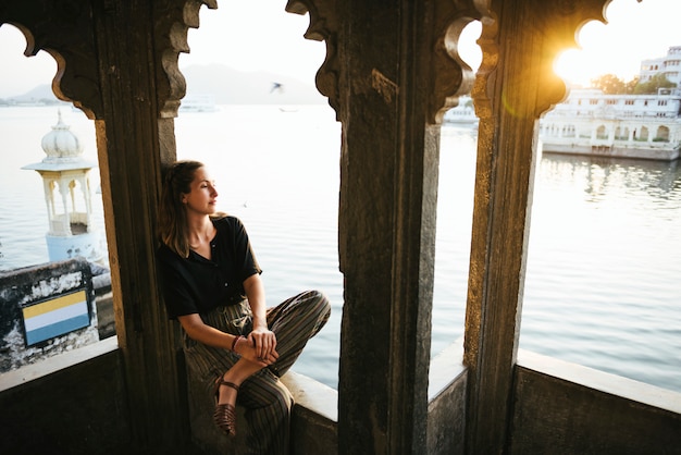 Mujer occidental sentada en una arquitectura cultural en Udaipur, India