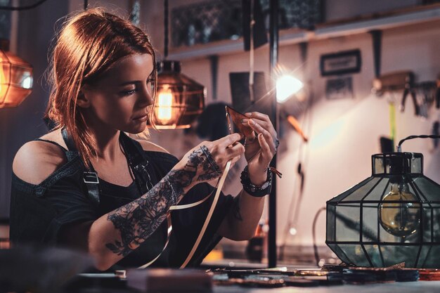 Una mujer ocupada y diligente está trabajando en un estudio de lámparas con cinta y triángulos coloridos.