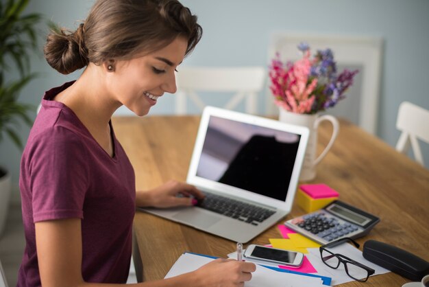 Mujer ocupada tomando algunas notas importantes