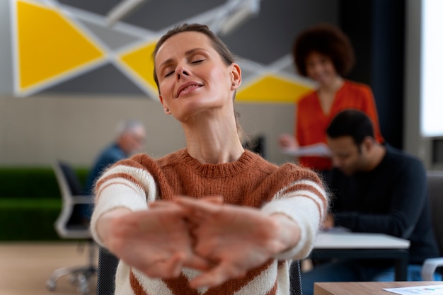 Foto gratuita mujer en la oficina estirándose durante un día de trabajo