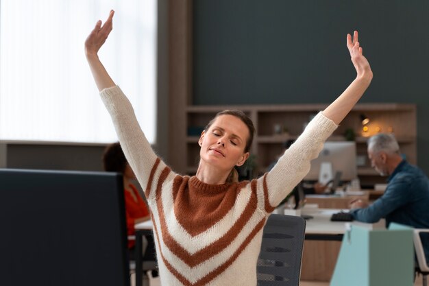 Mujer en la oficina estirándose durante un día de trabajo