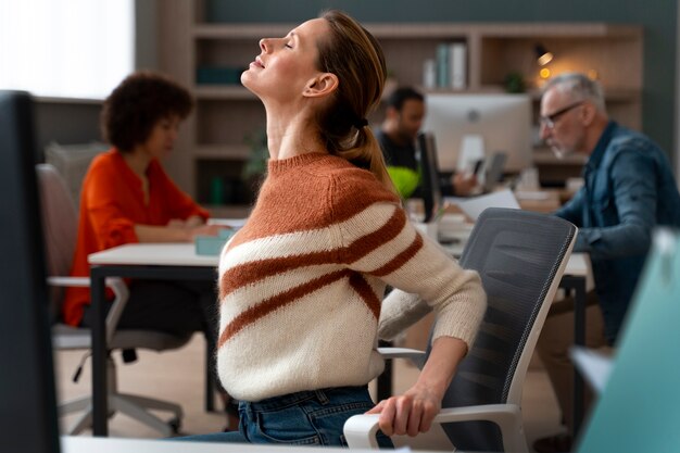 Mujer en la oficina estirándose durante un día de trabajo