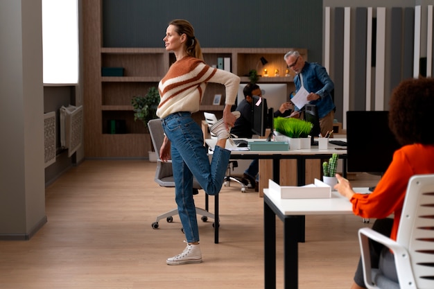 Mujer en la oficina estirándose durante un día de trabajo