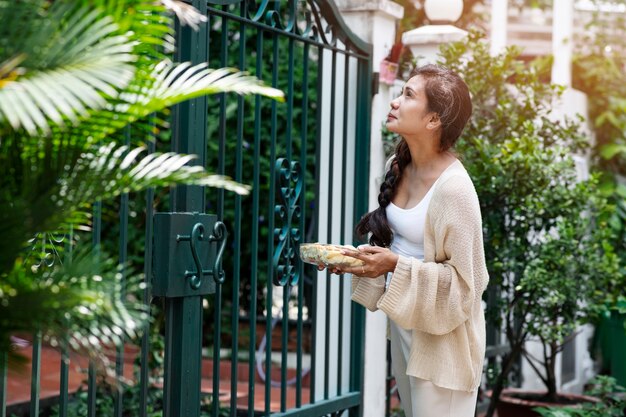 Mujer ofreciendo comida al vecino