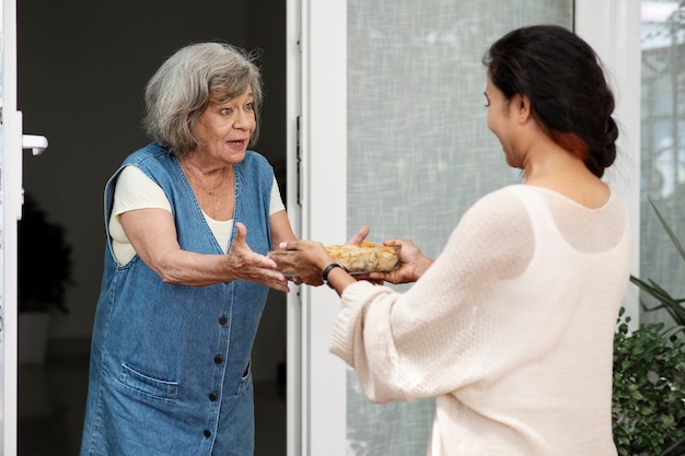 Mujer ofreciendo comida al vecino