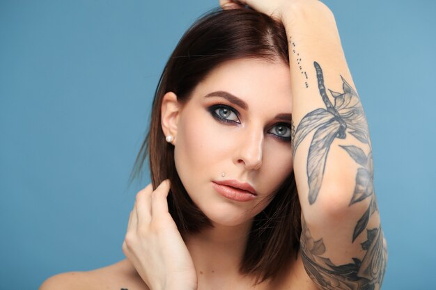 Mujer con ojos azules y tatuaje de mariposa