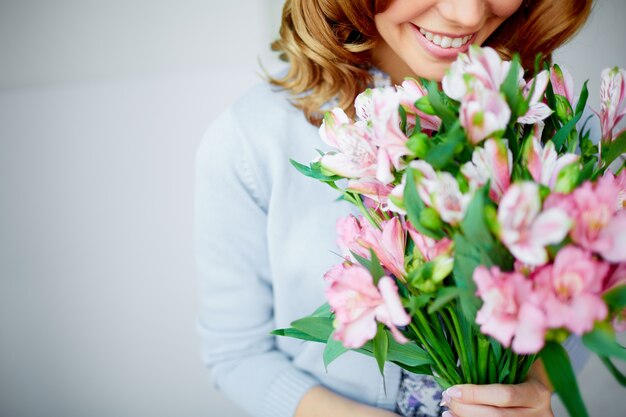 Mujer oliendo un ramo de flores