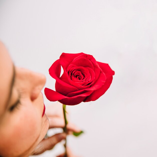 Mujer oliendo en rosa roja