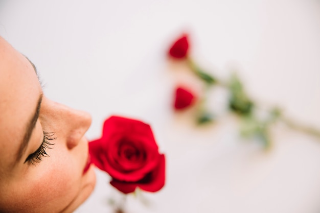 Mujer oliendo rosa