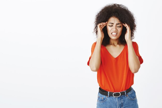 Mujer olvidadiza con peinado afro posando en el estudio