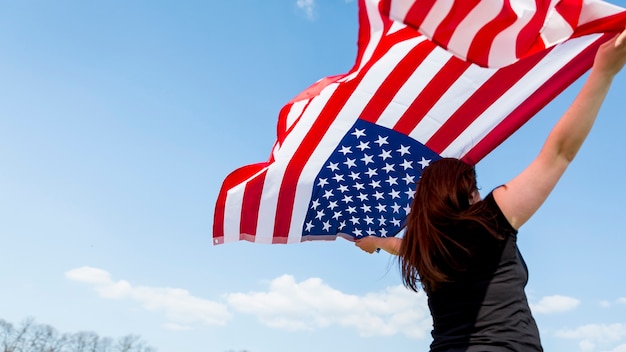 Mujer ondeando la bandera de Estados Unidos durante la celebración del Día de la Independencia