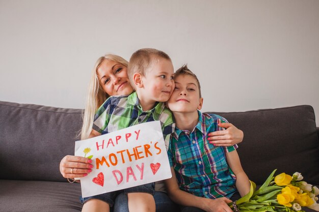 Mujer orgullosa posando con sus hijos para el día de la madre