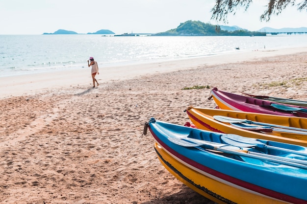 Mujer en la orilla del mar con barcos