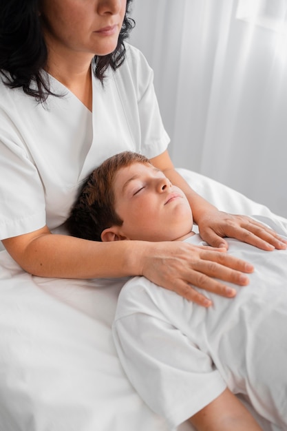 Mujer osteópata tratando a un niño