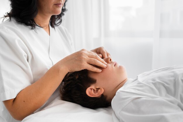 Mujer osteópata tratando a un niño