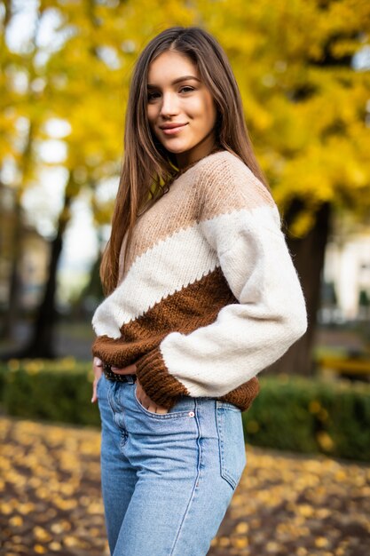 Mujer otoño en suéter en el parque otoño. Clima cálido y soleado. Concepto de otoño