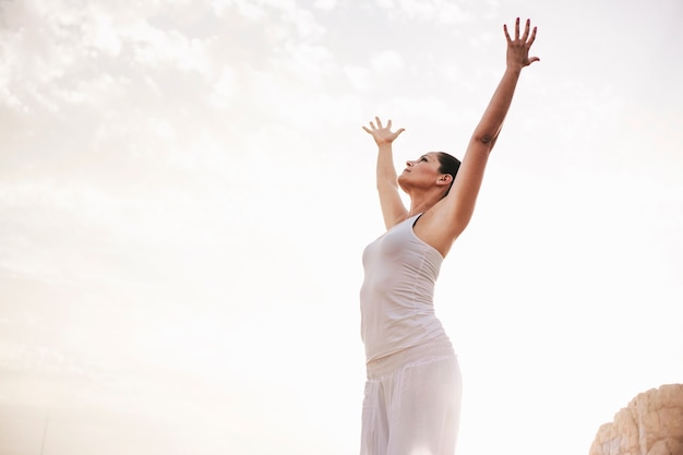 Mujer pacifica estirando brazos hacia el cielo