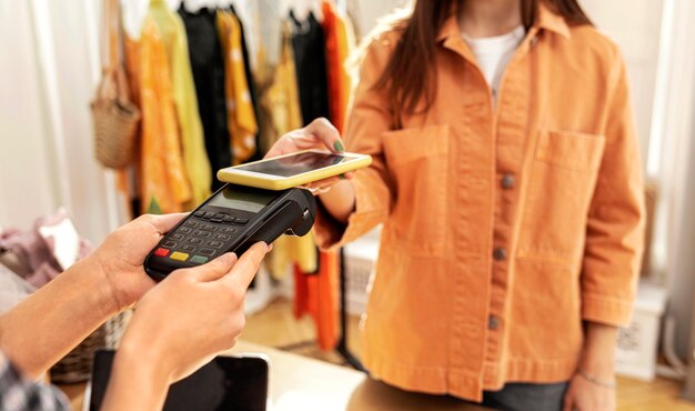 Mujer pagando ropa en tienda