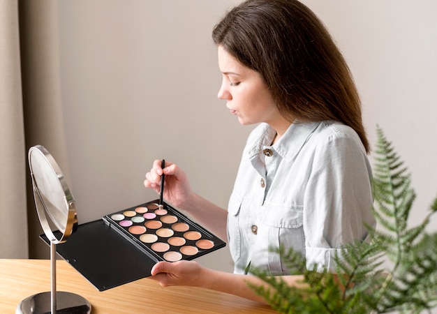 Mujer con paleta de sombra de ojos