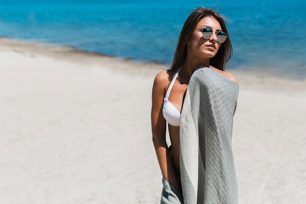 Foto gratuita mujer con pañuelo de playa mirando a otro lado