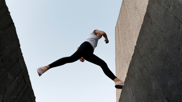 Mujer parkouring sobre edificios