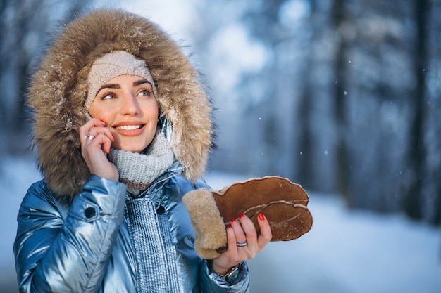 Mujer en un parque de invierno hablando por teléfono