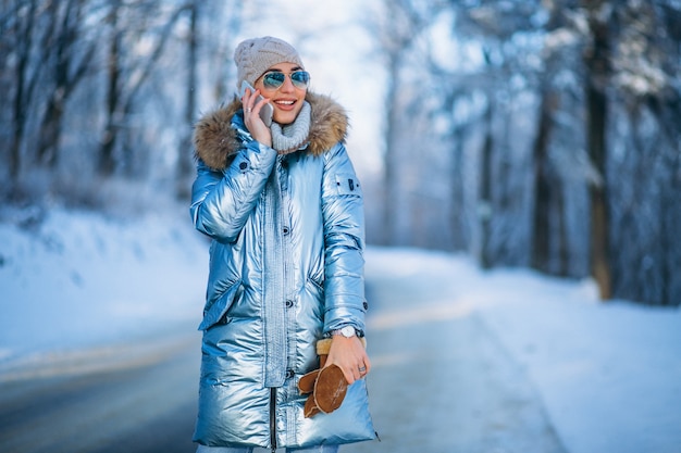 Mujer en un parque de invierno hablando por teléfono