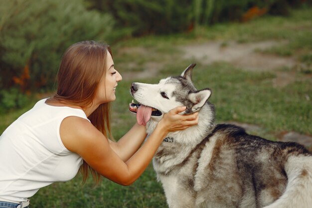 Mujer en un parque de primavera jugando con lindo perro