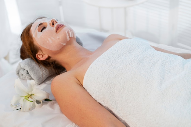 Mujer pasando tiempo en el spa con un tratamiento de mascarilla