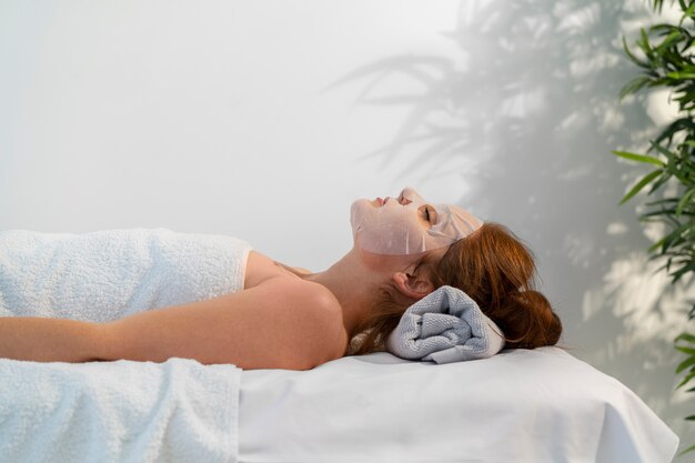 Mujer pasando tiempo en el spa con un tratamiento de mascarilla