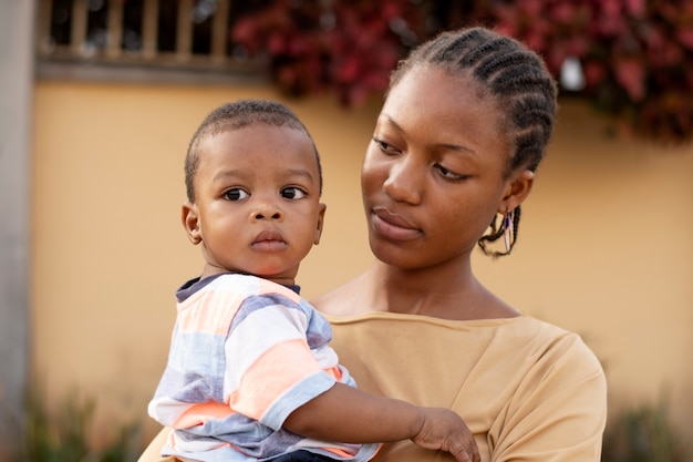 Foto gratuita mujer pasar tiempo con su bebé negro